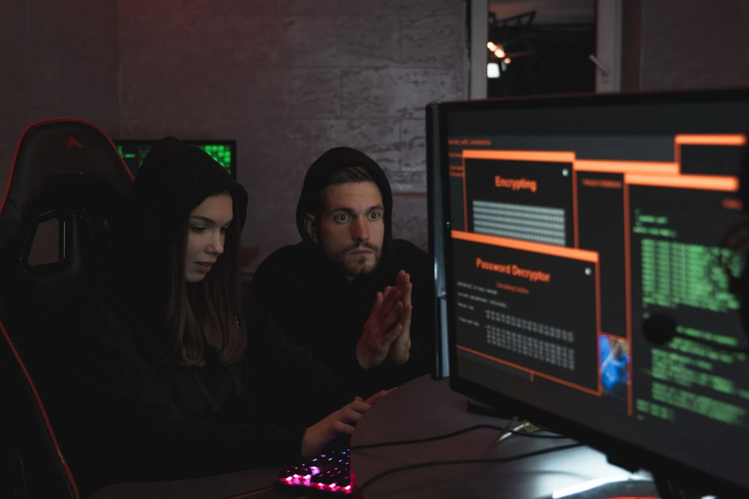 Two cybersecurity specialists examining security tools on computer screens